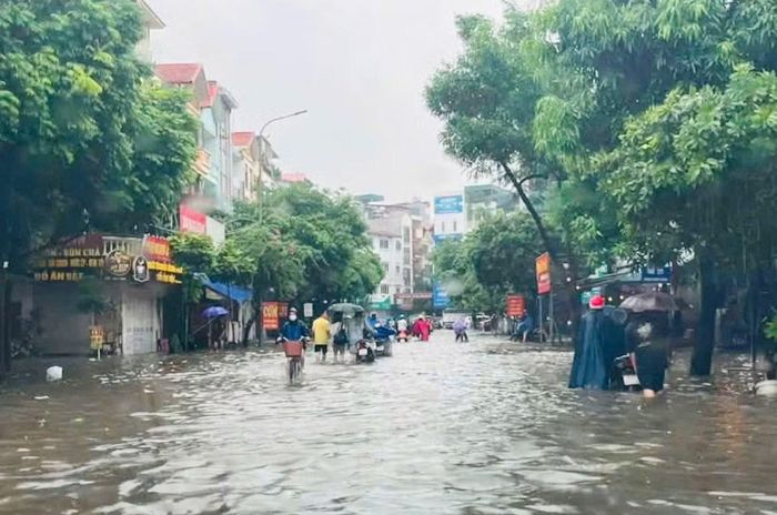 Đường Chiến Thắng (Hà Đông) ngập sâu khiến việc đi lại khó khăn, nhiều người phải dắt xe do chết máy. Ảnh: THIÊN LAM