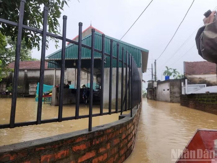 Chính quyền xã dùng thuyền nhỏ đi kiểm tra nhằm bảo đảm người dân bị ngập lụt được sơ tán tới nơi an toàn, điện lưới được cắt để tránh nguy hiểm. Ảnh chụp chiều tối ngày 16/9.