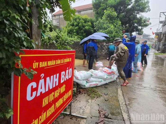 Các lực lượng chức năng cùng người dân tiếp tục gia cố để ngăn nước xâm nhập khu dân cư. Ảnh chụp chiều tối ngày 16/9.
