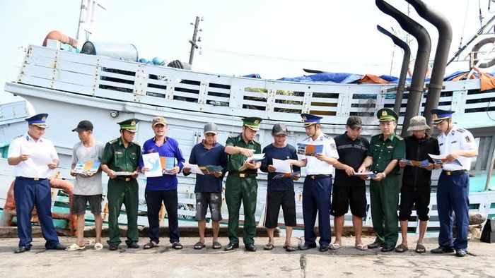 Bộ đội biên phòng Thành phố Hồ Chí Minh và Cảnh sát biển 3 phát tờ rơi tuyên truyền phòng chống IUU tại cảng cá Cát Lở. (Ảnh: Cảnh sát biển cung cấp)