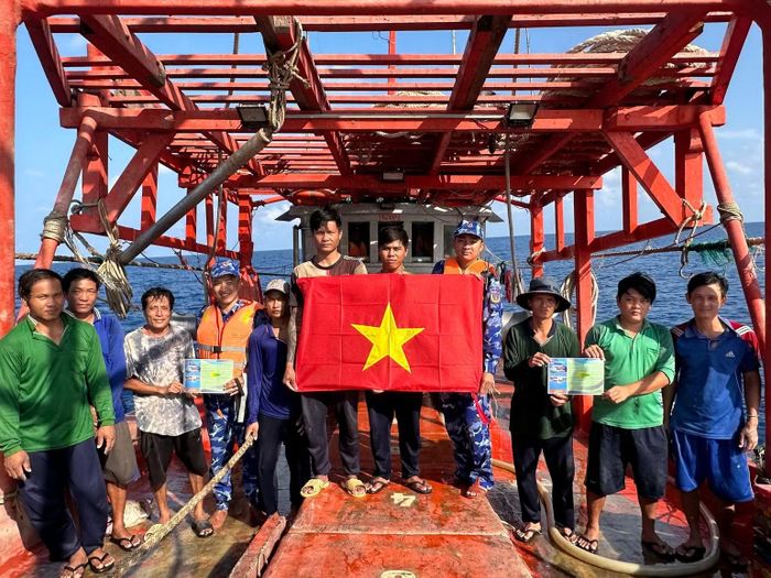 Tặng cờ Tổ quốc cho ngư dân ở Côn Đảo. (Ảnh: Cảnh sát biển cung cấp)