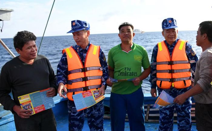 Phát tờ rơi tuyên truyền phòng chống IUU ở Côn Đảo (Ảnh: Cảnh sát biển cung cấp).