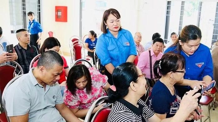 Tổ công nghệ số phường Minh Xuân, thành phố Tuyên Quang hướng dẫn người dân quét mã QR. (Ảnh: ĐỨC THẮNG)