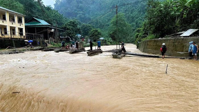 Đồn Biên phòng Tam Hợp cùng các lực lượng trên địa bàn bắc cầu tạm trên tuyến đường nước lũ chia cắt. (Ảnh: LÊ THẠCH)