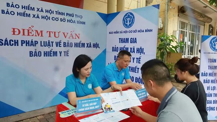 Cán bộ cơ quan Bảo hiểm xã hội cơ sở Hòa Bình (Phú Thọ) tư vấn chính sách bảo hiểm xã hội, bảo hiểm y tế cho người dân. (Ảnh: nhandan.vn)