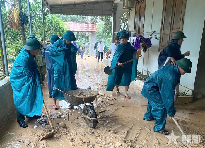 Cán bộ, nhân viên Ban CHQS xã Hoằng Giang giúp dân san gạt bùn đất.