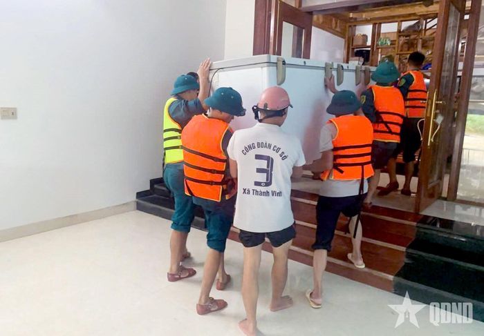Cán bộ, nhân viên Ban CHQS xã Thành Vinh hỗ trợ người dân di chuyển tài sản.