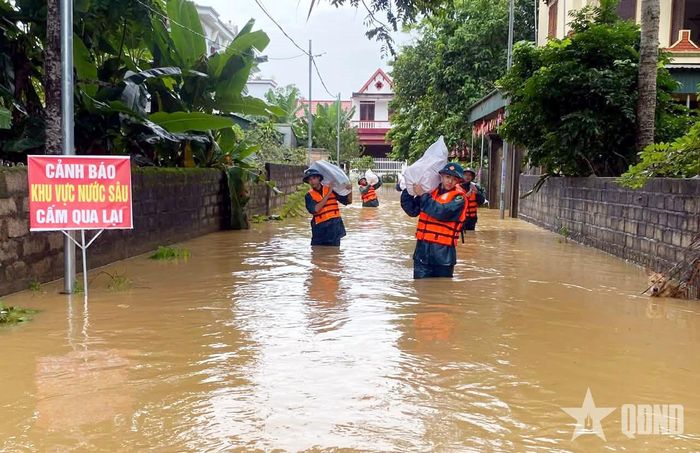 Cán bộ, nhân viên Ban CHQS xã Vân Du giúp nhân dân vận chuyển lương thực đến vị trí an toàn.