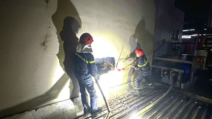 Lực lượng chức năng phá tường để tiếp cận căn nhà bị cháy