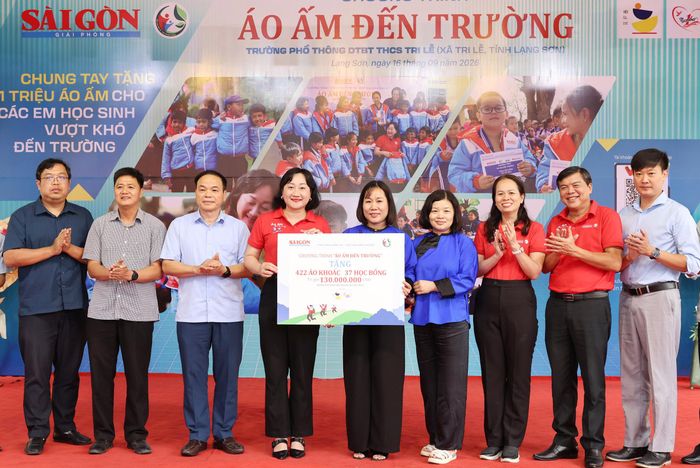 Phó Trưởng Ban Tuyên giáo Thành ủy TPHCM Tăng Hữu Phong và Phó Tổng Biên tập Báo SGGP Bùi Thị Hồng Sương trao bảng biểu trưng tặng áo ấm và học bổng tới học sinh Trường Phổ thông Dân tộc bán trú THCS Tri Lễ, xã Tri Lễ, tỉnh Lạng Sơn, chiều 16-9. Ảnh: QUANG PHÚC