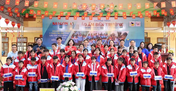 Phó Trưởng Ban Tuyên giáo Thành ủy TPHCM Tăng Hữu Phong và Phó Tổng Biên tập Báo SGGP Bùi Thị Hồng Sương cùng lãnh đạo xã Tri Lễ chụp ảnh cùng các học sinh nhận học bổng. Ảnh: QUANG PHÚC