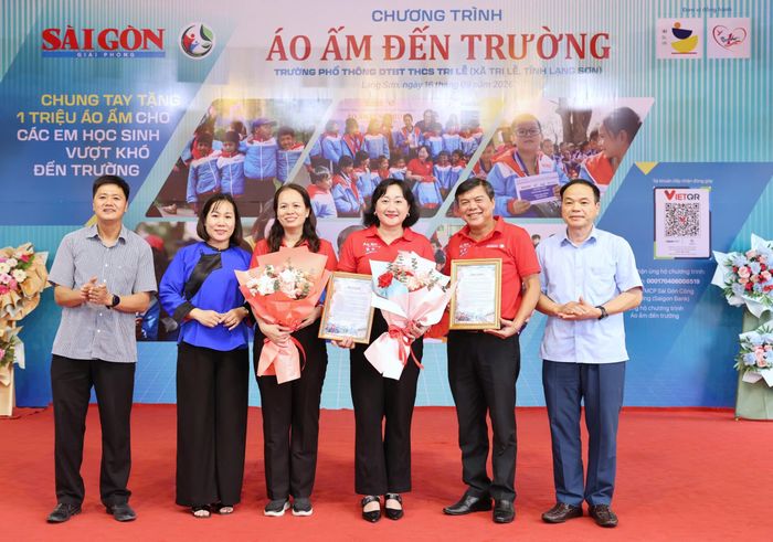 Lãnh đạo nhà trường và chính quyền xã Tri Lễ tặng chứng nhận và hoa đến đại diện đơn vị tổ chức. Ảnh: QUANG PHÚC