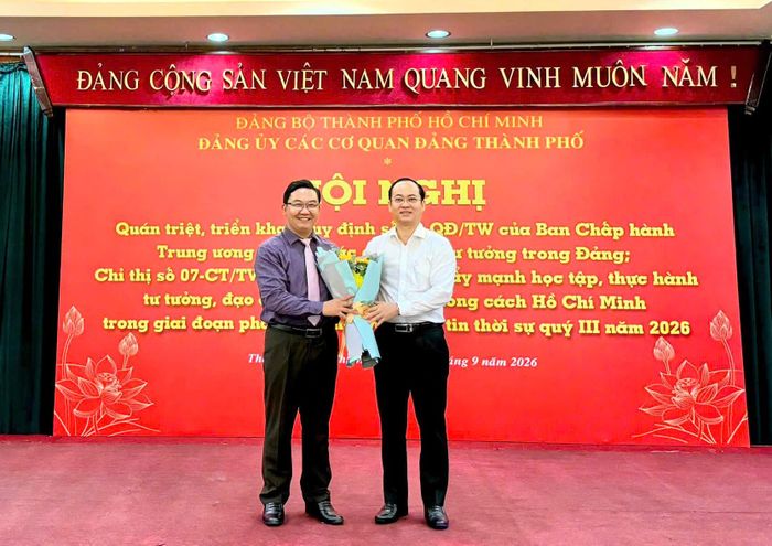  Phó Bí thư Đảng ủy các cơ quan Đảng TPHCM Nguyễn Khoa Hải tặng hoa cho báo cáo viên Đặng Văn Khoa. Ảnh: KHÁNH HUY 