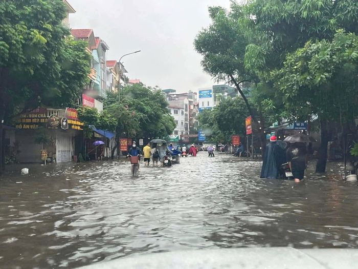 Gần giữa trưa khu vực Văn Quán vẫn ngập sâu trong nước. Ảnh: TIẾN CƯỜNG