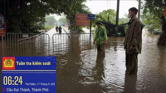Nước sông Đáy lên ngập cầu dân sinh nối xã An Khánh và Hưng Đạo (Hà Nội). Lực lượng chức năng kiểm soát, đảm bảo an toàn cho người dân tại khu vực. Ảnh: HỮU HOÀNG