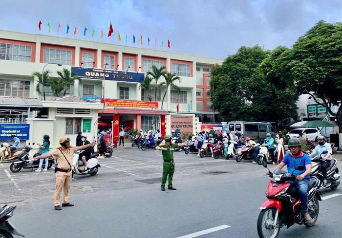  Cảnh sát giao thông phối hợp cùng lực lượng tại địa phương điều tiết giao thông trước cổng trường 