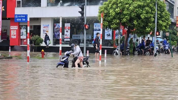 Khu vực đường Hoàng Tùng, gần cổng chào KĐT Nam An Khánh các phương tiện di chuyển khó khăn vì ngập sâu. Ảnh: Đình Tuệ.