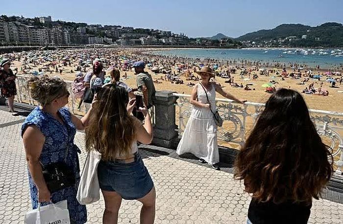 Du khách chụp ảnh trên tuyến đường ven vịnh La Concha ở thành phố San Sebastian, vùng Basque, Tây Ban Nha. (Nguồn: Getty Images)