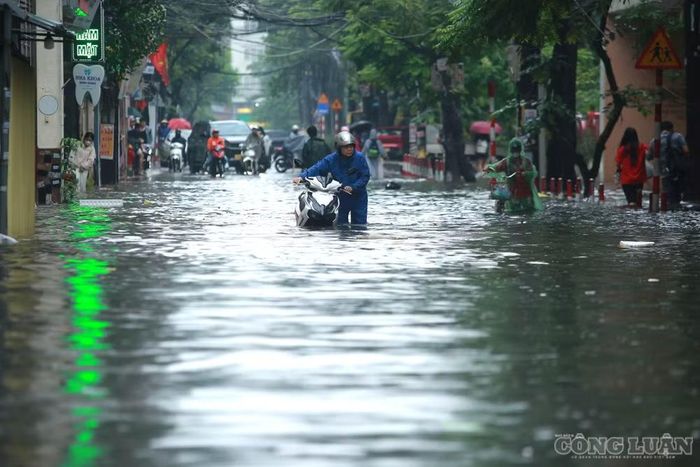 Một số xe máy cố gắng vượt qua khu vực ngập đã bị chết máy. Người dân phải xuống xe, dắt bộ giữa dòng nước để tìm cách di chuyển ra khỏi khu vực ngập.
