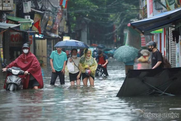 Đầu giờ sáng, khi lượng người và phương tiện bắt đầu tăng cao, tình trạng ngập úng càng khiến giao thông trở nên khó khăn. Người dân phải dò từng bước qua những đoạn đường ngập nước để bảo đảm an toàn.