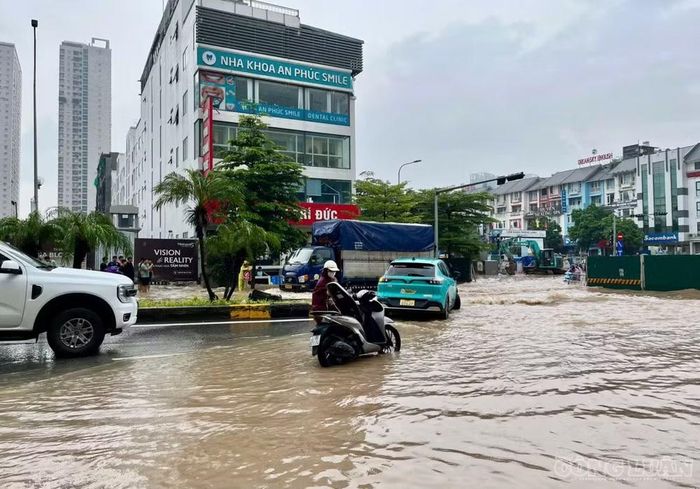 Người điều khiển xe máy dắt bộ qua vị trí ngập.