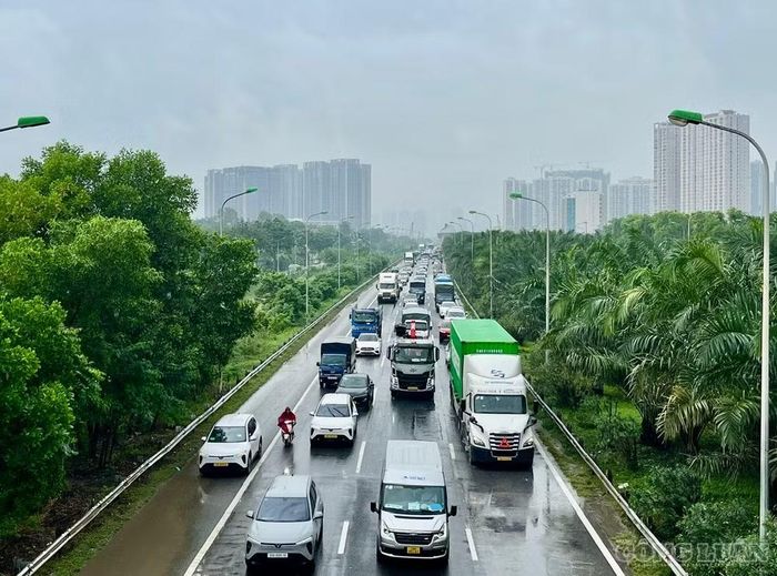 Nhiều xe máy đi vào làn ô tô trên Đại lộ Thăng Long do đường gom ngập nặng.