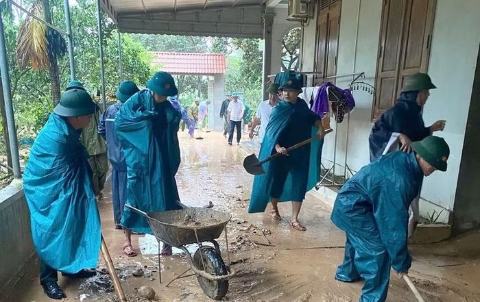 Cán bộ, nhân viên Ban Chỉ huy Quân sự xã Hoằng Giang (Thanh Hóa) giúp nhân dân san gạt bùn đất (ảnh: Hoàng Khánh Trình).