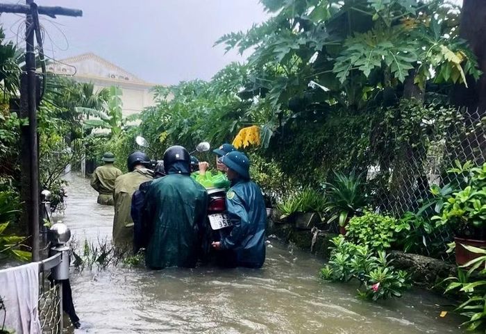 Cán bộ, chiến sĩ lực lượng vũ trang tỉnh Thanh Hóa cùng lực lượng địa phương hỗ trợ người dân di chuyển phương tiện ra khỏi khu vực ngập sâu (ảnh: Hoàng Khánh Trình).