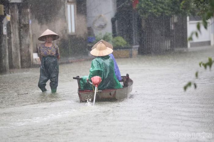 Mực nước dâng cao khiến người dân phải sử dụng thuyền để di chuyển ngay trên mặt đường trong thôn.