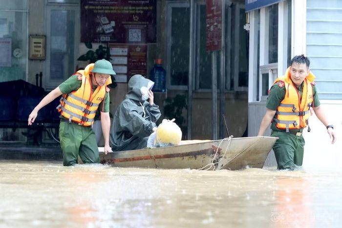Công an phường Hoàng Mai huy động thuyền vận chuyển bệnh nhân, thuốc và các vật tư cần thiết ra vào trung tâm y tế. Ảnh: Kim Long
