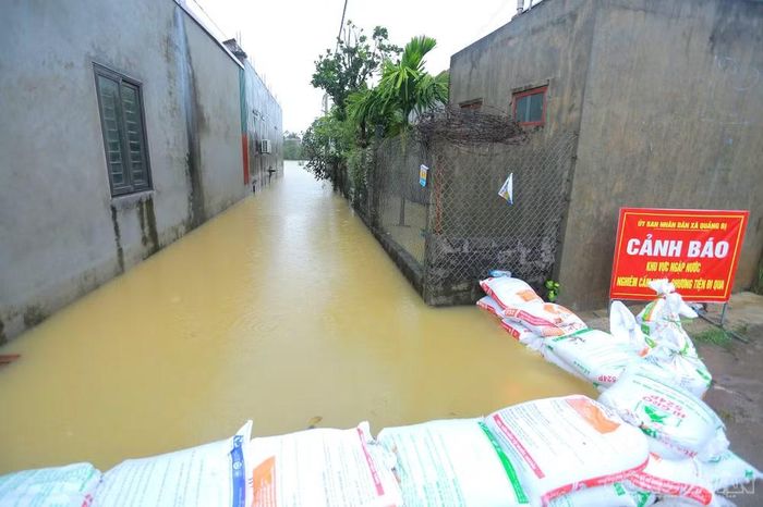 Nước ngập sâu, người dân đắp bao tải cát tại một số nơi để ngăn nước tràn vào, đồng thời đặt biển cảnh báo.