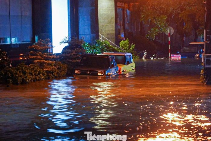 Nước bao quanh nhiều ô tô đỗ qua đêm trong các ngõ trên phố Thái Hà. Một số vị trí nước đã tràn lên vỉa hè, sát cửa nhà dân.