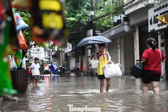 Tại ngõ Đỗ 99 Hoa Bằng và ngõ chợ 90 Hoa Bằng, nước ngập sâu khiến việc đi lại gặp nhiều khó khăn.