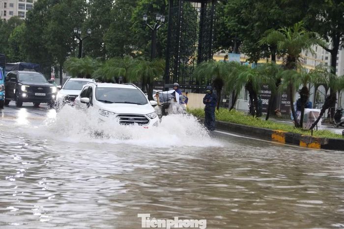 Dòng phương tiện nối dài trên tuyến phố ngập nước.