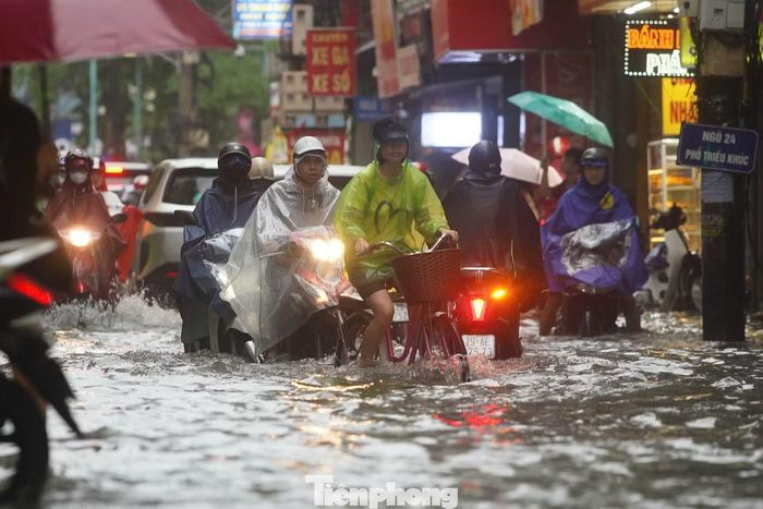 Phố Triều Khúc ngập sâu hàng trăm mét, người dân bì bõm lội nước đến trường, đi làm trong mưa lớn.