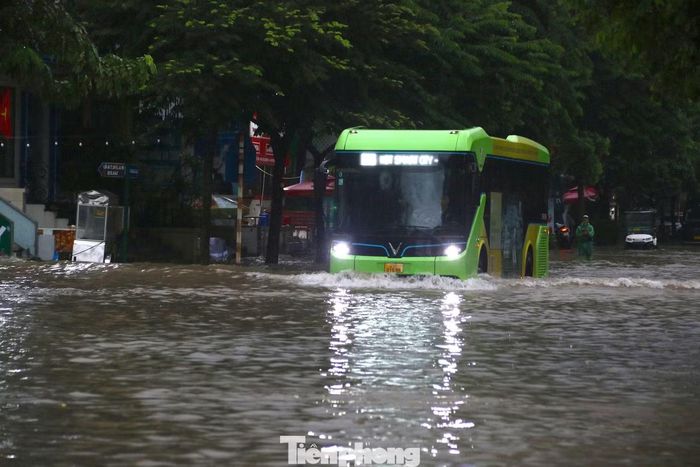 Nước dâng cao trên mặt đường khiến việc lưu thông của các phương tiện công cộng và người dân gặp nhiều khó khăn