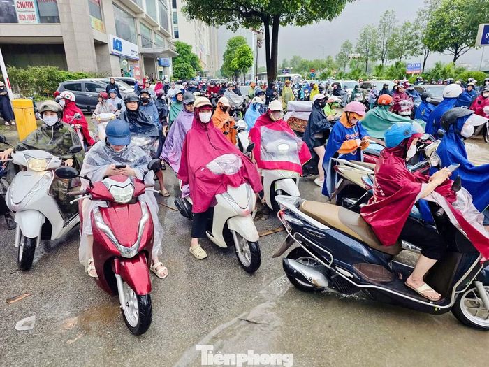 Nhiều người đưa xe lên vỉa hè, chờ dòng phương tiện phía trước di chuyển.