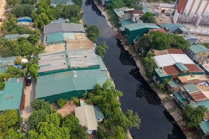 Lều lán, nhà xưởng mọc sát mép sông, cùng rác thải và vật liệu tập kết ngổn ngang, thu hẹp không gian ven sông, tiềm ẩn nguy cơ mất an toàn.