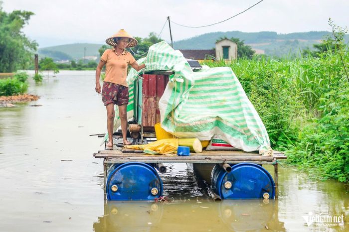 Người dân chuyển đồ đạc lên bè nổi. Ảnh: Lê Dương