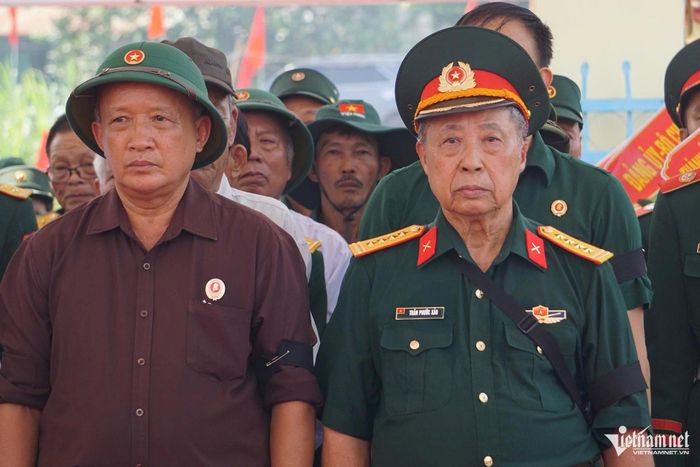 Ông Trần Phước Sảo (bên phải) xúc động khi 17 hài cốt của đồng đội được đưa về nghĩa trang liệt sĩ. Ảnh: Hà Nam