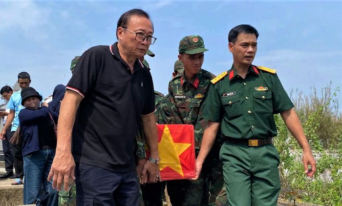 Ông Võ Đình Thế (trái) cùng lực lượng quân sự đưa các hài cốt từ xã Thu Bồn về xã Hiệp Đức, chuẩn bị cho lễ truy điệu. Ảnh: Đinh Thế