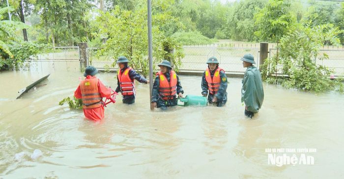 Lực lượng Quân sự địa phương đang giúp dân thu gom tài sản, vật dụng bị nước cuốn trôi. Ảnh: Nguyễn Nam