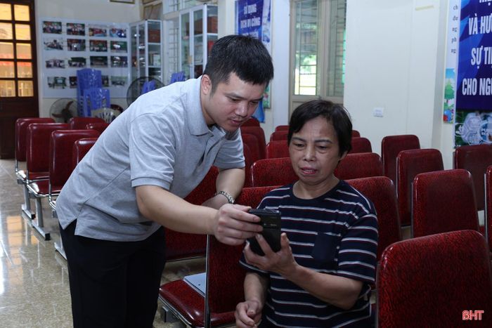 Anh Trần Hoàng Anh, Tổ trưởng Tổ dân phố 29 hướng dẫn người dân cài đặt các tiện ích số trên điện thoại thông minh.
