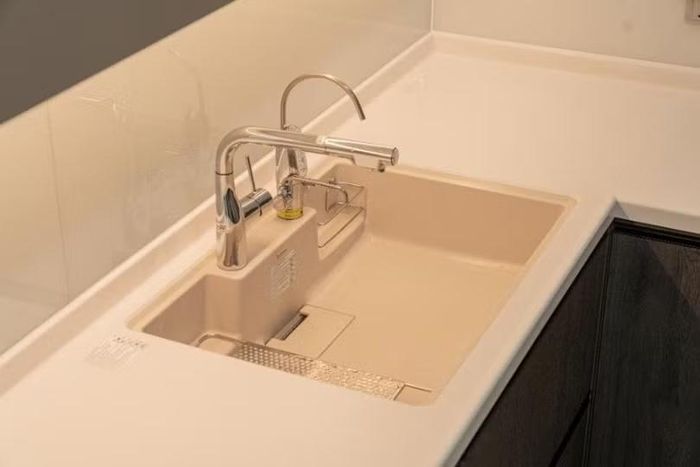 Bếp hoàn thiện với mặt BMC và chậu đá gắn âm - tổng thể liền mạch từ chậu rửa đến tấm chắn tường.