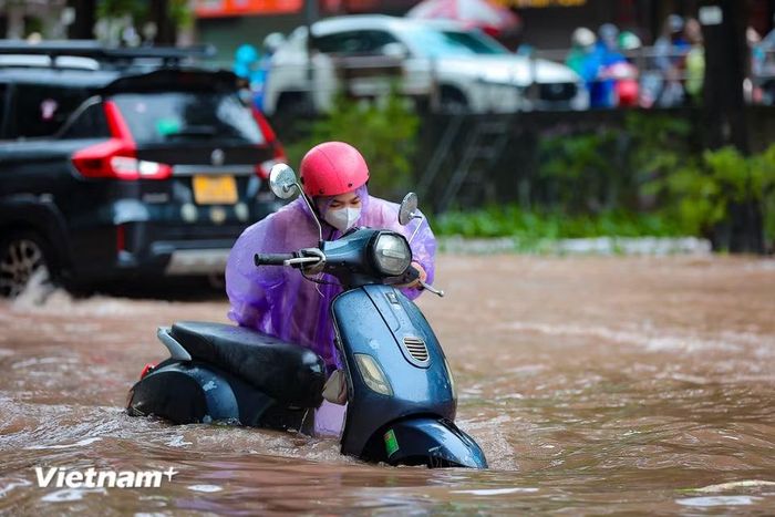 Nhiều phương tiện đã chết máy giữa dòng nước. (Ảnh: Hoài Nam/Vietnam+)