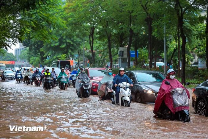 Ghi nhận tại tuyến phố Thái Hà sáng nay có đoạn nước ngập sâu, người dân di chuyển rất khó khăn. (Ảnh: Hoài Nam/Vietnam+)