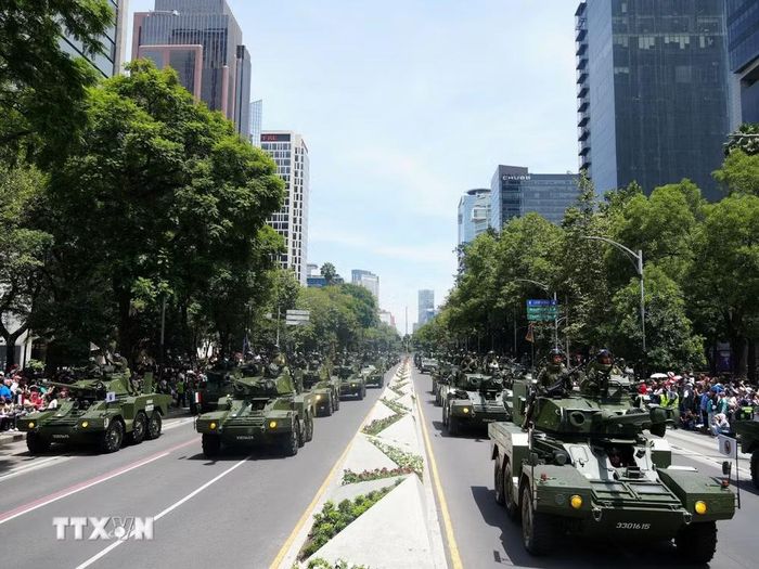 Hàng dài các xe thiết giáp bọc thép thuộc Lực lượng Vũ trang Mexico rầm rộ tiến qua đại lộ Paseo de Reforma, thể hiện sức mạnh cơ động và hiện đại của quân đội quốc gia. (Ảnh: Phi Hùng/TTXVN)