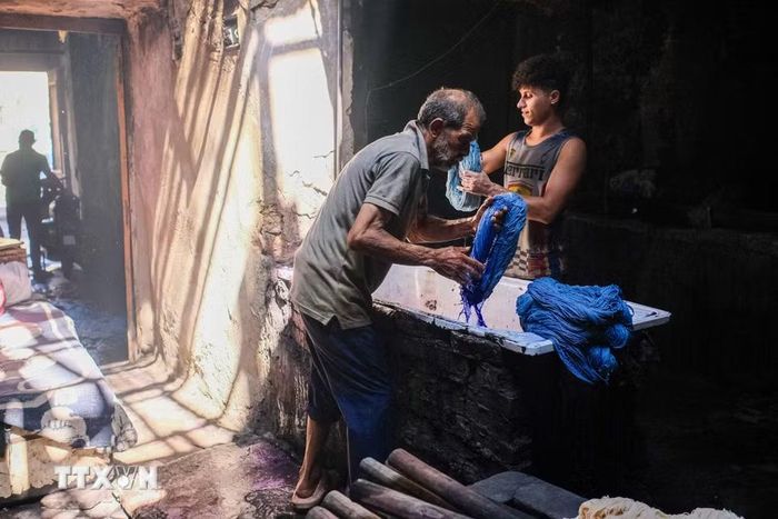 Một người thợ nhuộm các cuộn sợi tại xưởng nhuộm Salama ở Cairo, Ai Cập, ngày 16/9/2026. (Ảnh: THX/TTXVN phát)
