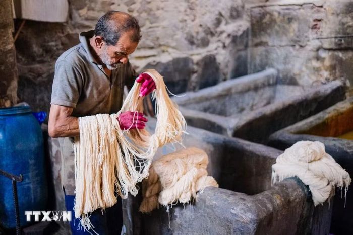 Một người thợ nhuộm các cuộn sợi tại xưởng nhuộm Salama ở Cairo, Ai Cập, ngày 16/9/2026. (Ảnh: THX/TTXVN phát) ả