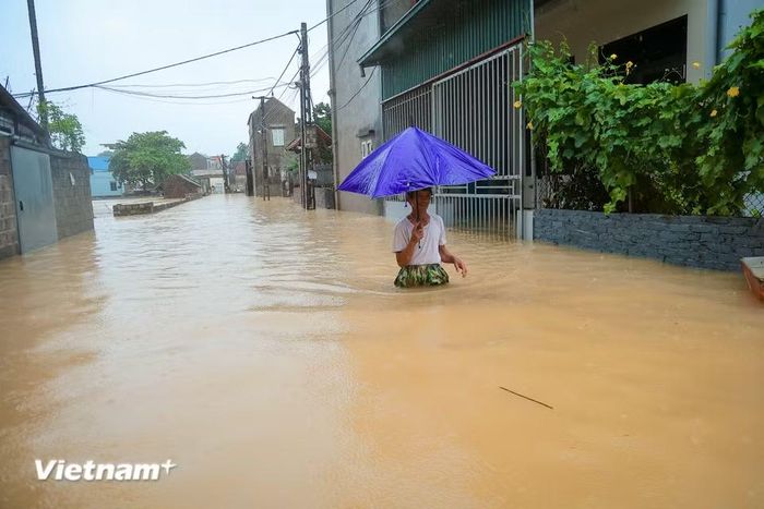 Người dân bì bõm lội nước để di chuyển. (Ảnh: Hoài Nam/Vietnam+)